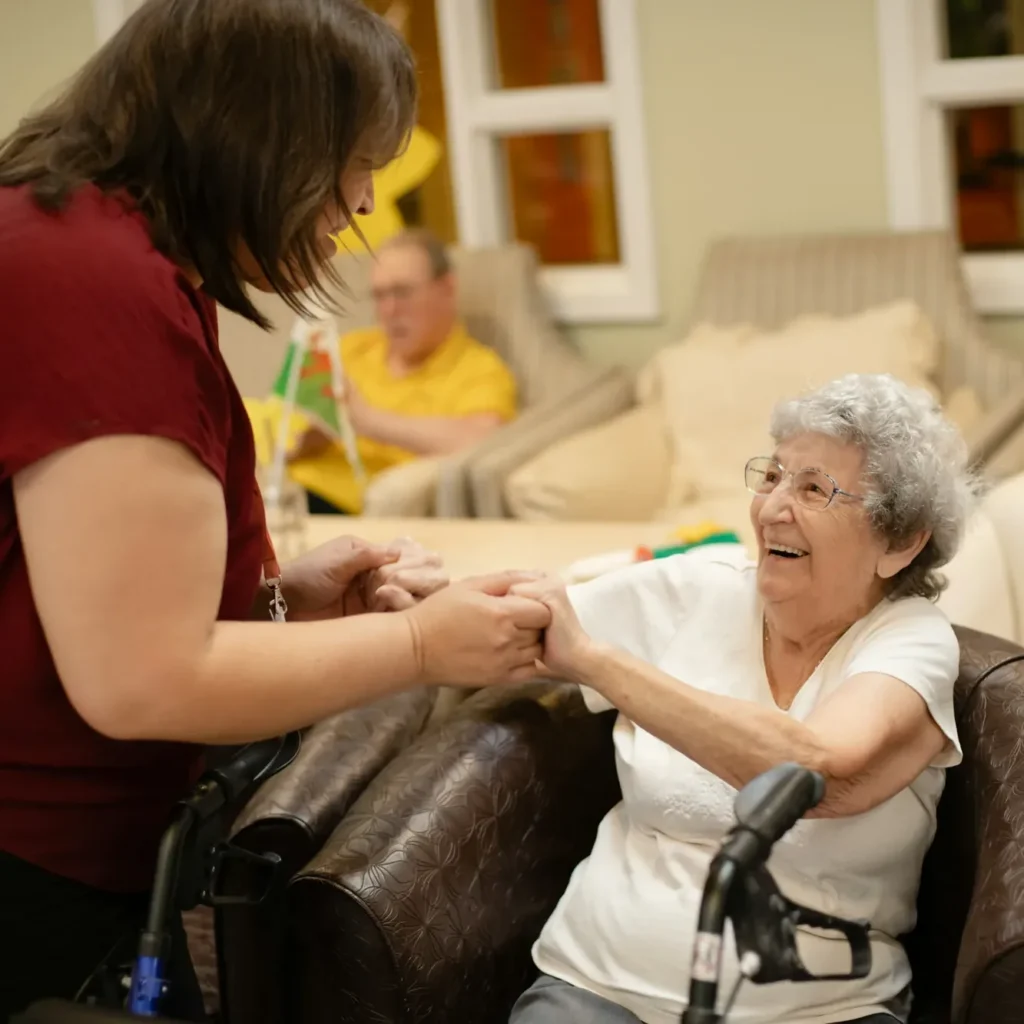 A facilitator holding a resident's hand during a one-to-one session
