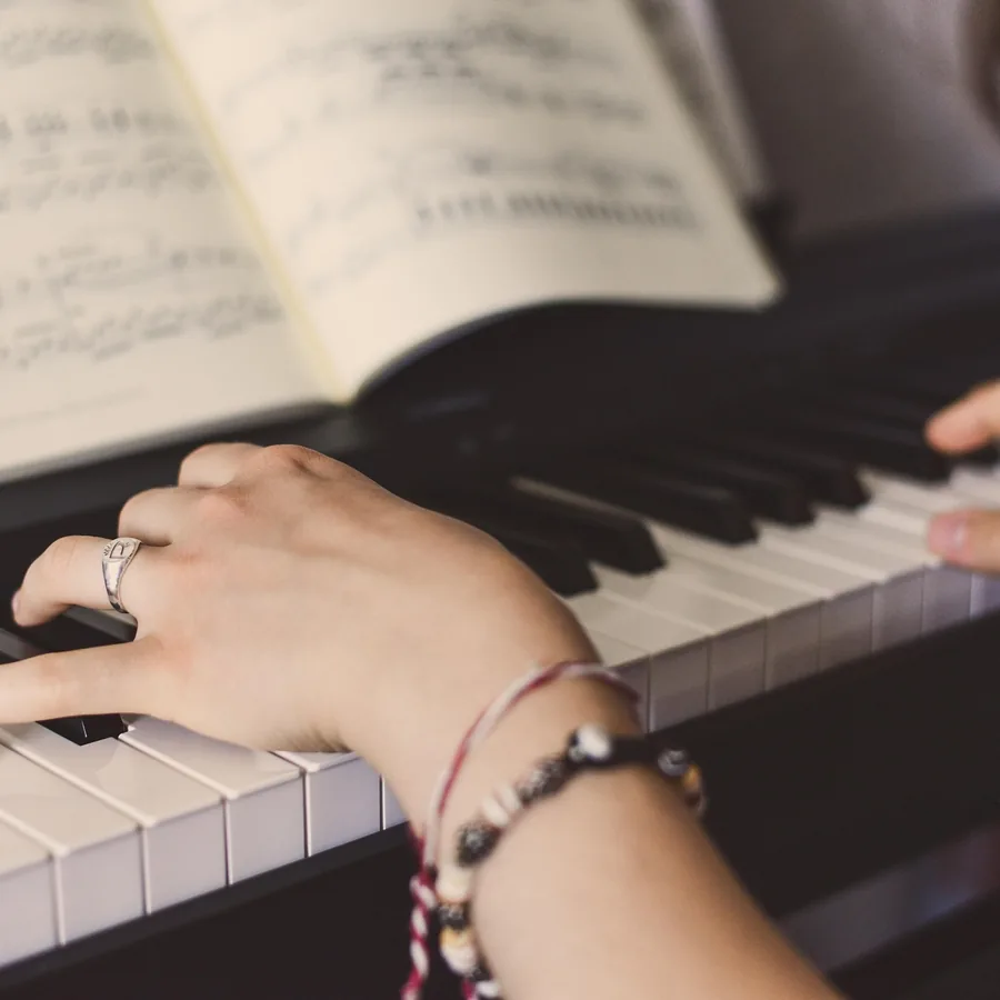 Close-up of hands playing piano keys